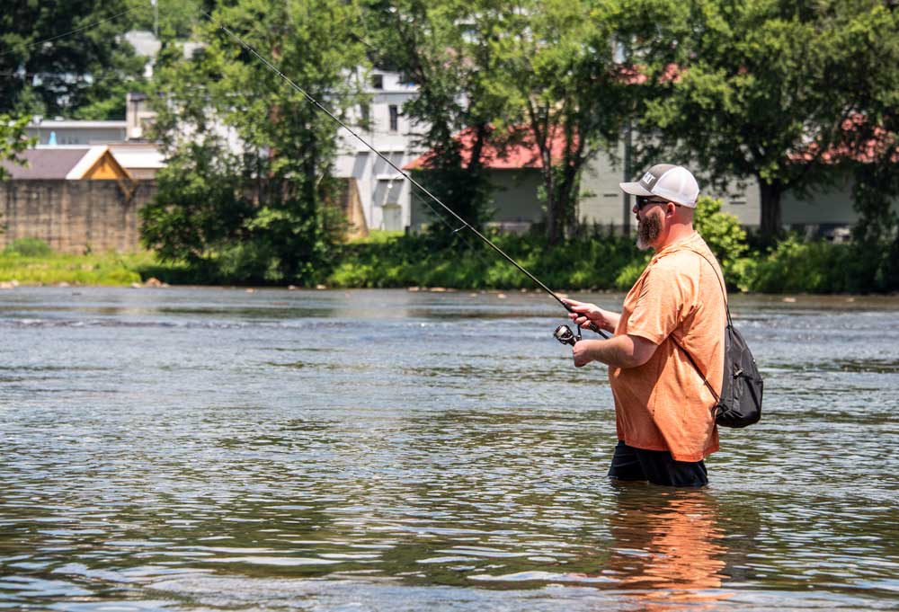 Man wading and fishing for smallmouth bass in New River at Fries, Virginia
